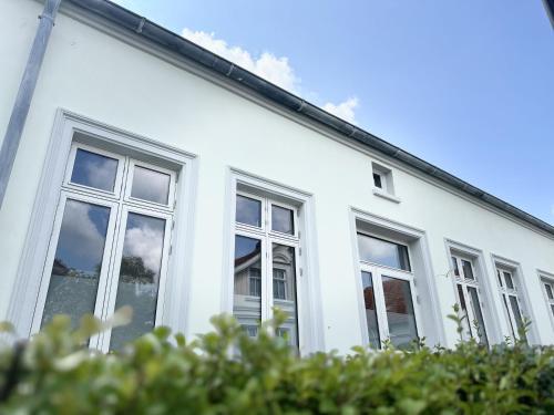a white house with windows on the side of it at Friesenhus - Jever in Jever