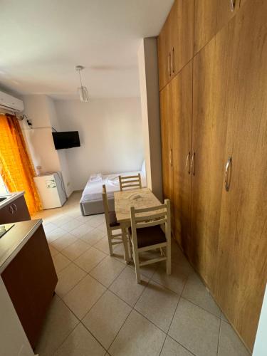 a room with a table and a bedroom with a bed at Ridi Apartament's in Vlorë