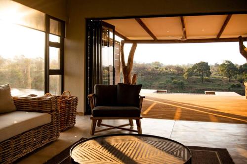 Simbini Sunset Cottage في ماليلين: غرفة معيشة مع أريكة وكرسي