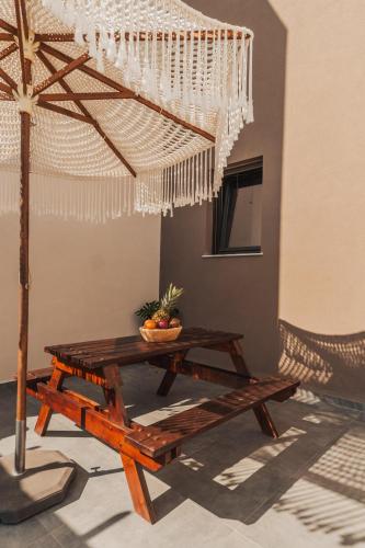 a wooden table with a bowl of fruit on top at Nos Aqua Villas Chania in Pazinos