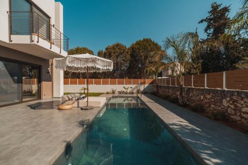 a swimming pool in the backyard of a house at Nos Aqua Villas Chania in Pazinos