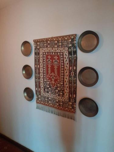 a rug hanging on a white wall with wooden circles at Boulevard Inn Mt Meru in Arusha