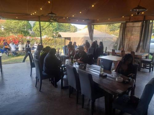 a group of people sitting at a table in a restaurant at Boulevard Inn Mt Meru in Arusha