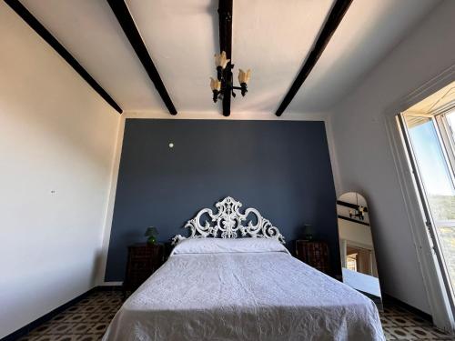 a bedroom with a white bed with a blue wall at RARE Soggiorno Elegante in Vibonati