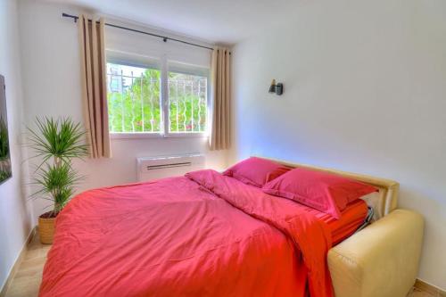 a bedroom with a bed with red sheets and a window at Charmant Studio rénové à Antibes, plage à 10 min à pied in Antibes