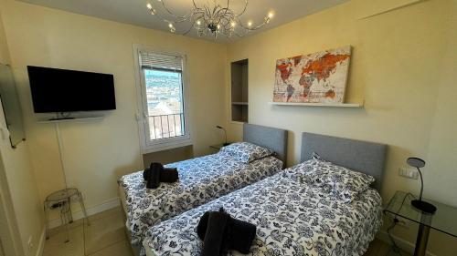 une chambre avec deux lits et une télévision à écran plat dans l'établissement Luxurious Cannes Two Bedrooms, à Cannes