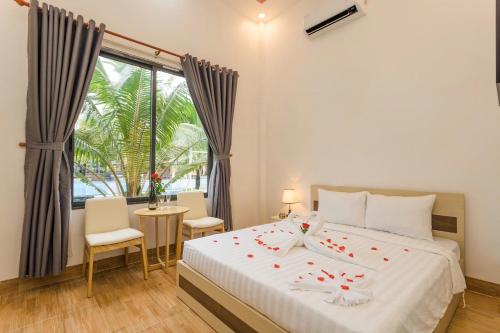 a bedroom with a bed with roses on it at Thuong Trang Villa Phu Quoc in Phu Quoc