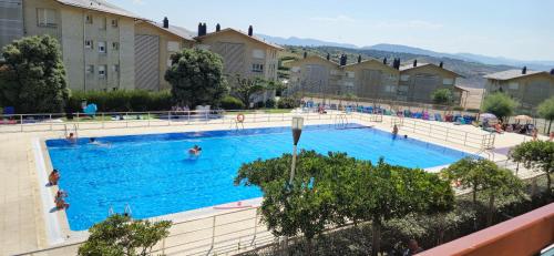 a large swimming pool with people swimming in it at Primera línea de playa Surf & Beach in Sopelana