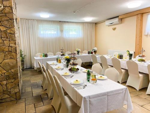 a dining room with white tables and white chairs at Dom Wypoczynkowy Relaks in Rytro
