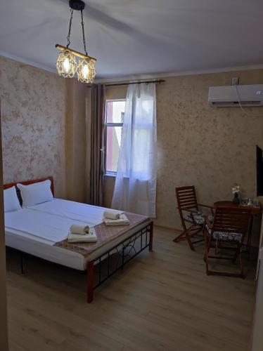 a bedroom with a bed and a table and a window at Guest Rooms Filipopol in Plovdiv