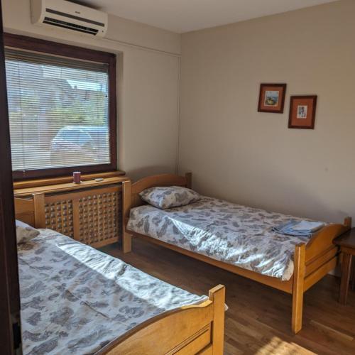two beds in a room with a window at Dolce Vita in Kragujevac