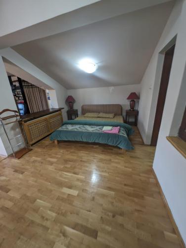 a bedroom with a bed and a wooden floor at Dolce Vita in Kragujevac