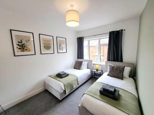 a bedroom with two beds and a window at Modern Newly Refurbished 3-Bedroom House in Lincoln