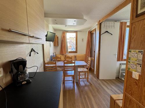une cuisine et une salle à manger avec une table et des chaises dans l'établissement Charmant studio divisible ski-in/ski-out avec balcon et animaux admis - FR-1-181-2129, à La Plagne Tarentaise