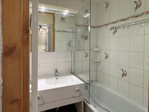 une salle de bain avec un lavabo, une baignoire et un miroir dans l'établissement Charmant studio divisible ski-in/ski-out avec balcon et animaux admis - FR-1-181-2129, à La Plagne Tarentaise