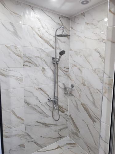a bathroom with a shower with white marble tiles at Guest Rooms Filipopol in Plovdiv