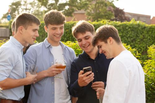 a group of men looking at a cell phone at Au Coin Quatorze in Poperinge