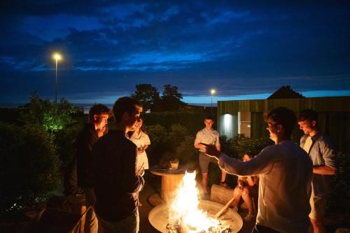 a group of people standing around a fire pit at Au Coin Quatorze in Poperinge