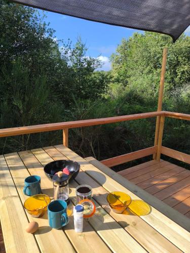 - une table en bois avec un bol de nourriture sur une terrasse dans l'établissement Moose Tiny House Basalt, à Cros