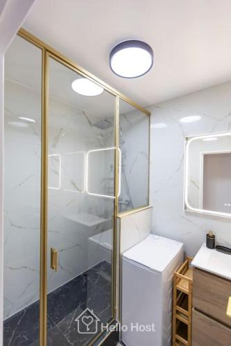 La salle de bains est pourvue d'une douche en verre et d'un réfrigérateur blanc. dans l'établissement La Chic Retraite Parisienne - Parking, 81m2, Paris, à Romainville
