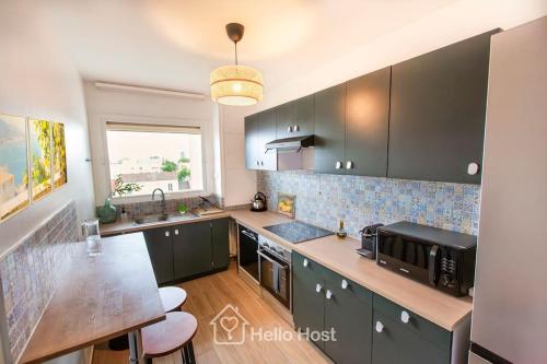 une cuisine avec des armoires noires et un comptoir dans l'établissement La Chic Retraite Parisienne - Parking, 81m2, Paris, à Romainville