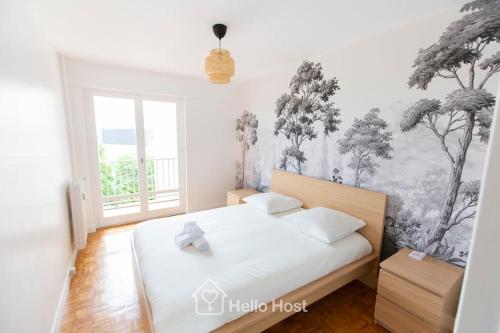 une chambre avec un lit avec une fresque d'arbres sur le mur dans l'établissement La Chic Retraite Parisienne - Parking, 81m2, Paris, à Romainville