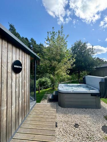 a hot tub on a wooden deck next to a building at Riverside Cabins in Shrewsbury