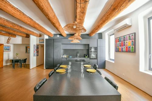 une grande table noire dans une pièce avec une cuisine dans l'établissement Appart standing avec 2 ch clim sur le Vieux-Port, à Marseille