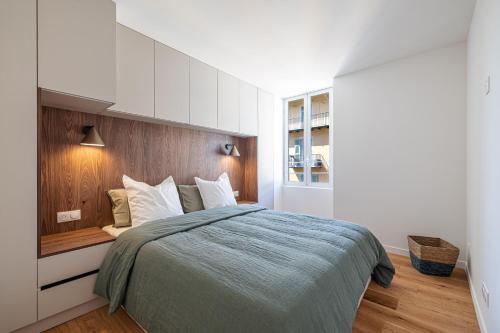une chambre avec un grand lit avec une tête de lit en bois dans l'établissement Appartement d'architecte Port de Nice, à Nice