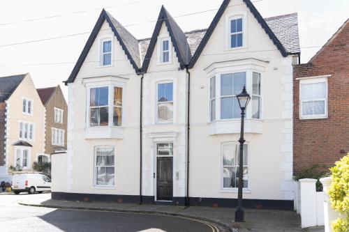 a white house with a black roof and a street light at Open Mind Property - Apartment with 2 Double Beds in Portsmouth