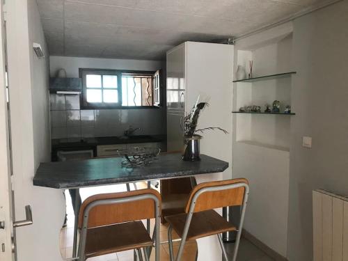 une cuisine avec une table et des chaises dans une pièce dans l'établissement Location studio proche de la mer - Martigues, à Martigues