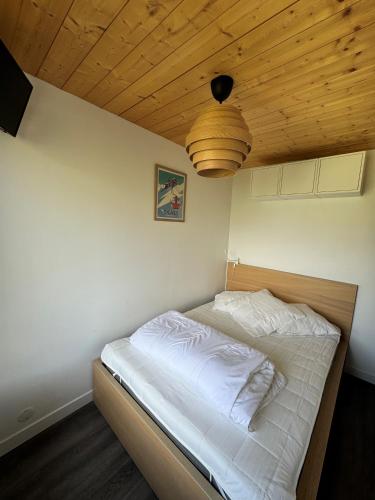 Ce lit se trouve dans une chambre dotée d'un plafond en bois. dans l'établissement Appartement Tignes Val claret, à Tignes