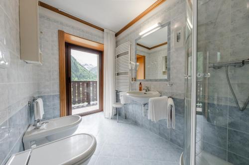 a bathroom with two sinks and a glass shower at Hotel Vioz in Peio Fonti