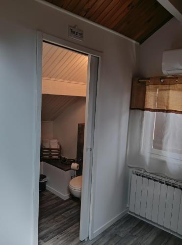La salle de bains est pourvue de toilettes, d'une fenêtre et d'une porte. dans l'établissement Chambre d'hôtes à mouleydier, à Mouleydier