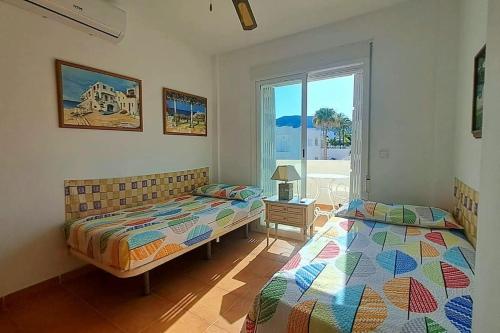 Un dormitorio con dos camas y una ventana. en Casa Blanca - Mojacar Playa, en Mojácar