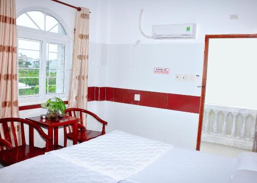 a bedroom with a bed and a table and a window at Guest House 36 (2) in Rạch Giá