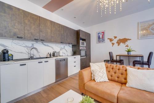 un salon avec un canapé et une cuisine dans l'établissement Le Clos des Menuts - Appt, quartier St-Catherine, à Bordeaux