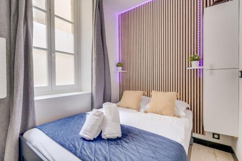 une chambre avec un lit avec deux oreillers dessus dans l'établissement Le Clos des Menuts - Appt, quartier St-Catherine, à Bordeaux