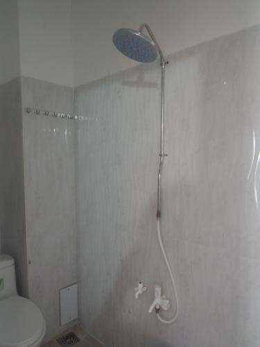 a bathroom with a shower with a toilet and a shower head at Guest House 36 (2) in Rạch Giá