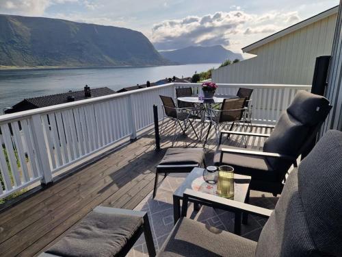 Un balcón con mesa y sillas y vista al agua. en Hessahuset, en Ålesund