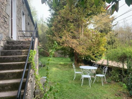 - une table et des chaises dans la cour d'une maison dans l'établissement Charmante Maison dans le Morvan, à Montsauche
