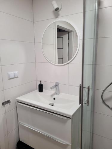 a white bathroom with a sink and a mirror at Axo-Hostel 13 in Stalowa Wola
