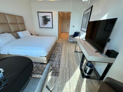 a hotel room with a bed and a flat screen tv at DAMAC Towers Riyadh by SELSAL داماك الرياض in Riyadh