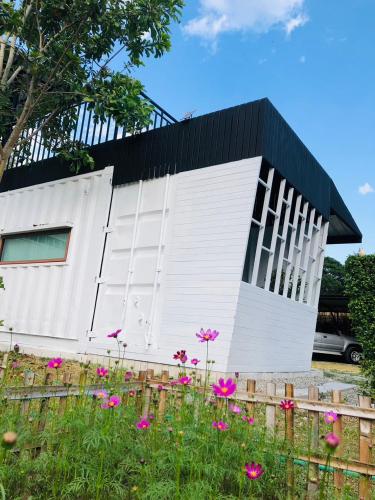 a white building with pink flowers in front of it at PMee Home in Ban Nong Hoi