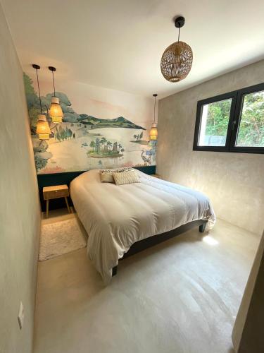 a bedroom with a bed with a painting on the wall at La Dépendance in Sciez