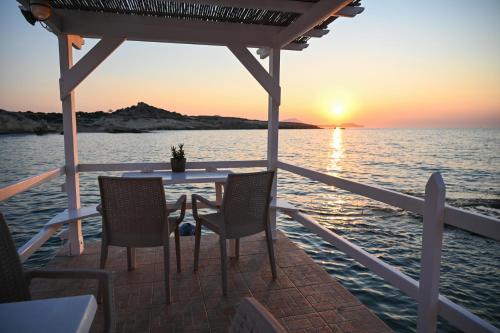a table and chairs on a boat at sunset at Fisherman's Syrma House in Pachaina