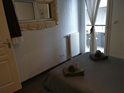 une chambre avec un lit avec deux serviettes dessus dans l'établissement T2 centre ville parking 19 thonon-o-phil-de-l-eau, à Thonon-les-Bains