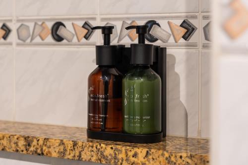 two bottles of soap sitting on a counter at Modern & Spacious 2-Bed Condo with Panoramic Lake Views, Dual Balconies, Steps from Dubai JLT Metro By "La Buena Vida Holiday Homes" in Dubai