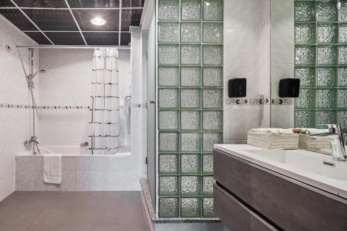 a bathroom with a shower and a sink and a tub at Modern & Spacious 2-Bed Condo with Panoramic Lake Views, Dual Balconies, Steps from Dubai JLT Metro By "La Buena Vida Holiday Homes" in Dubai