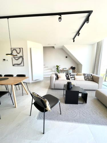 a living room with a couch and a table at MOLO roof - stylish penthouse with marina view Blankenberge within walking distance from the sea - 15 km from Bruges in Blankenberge